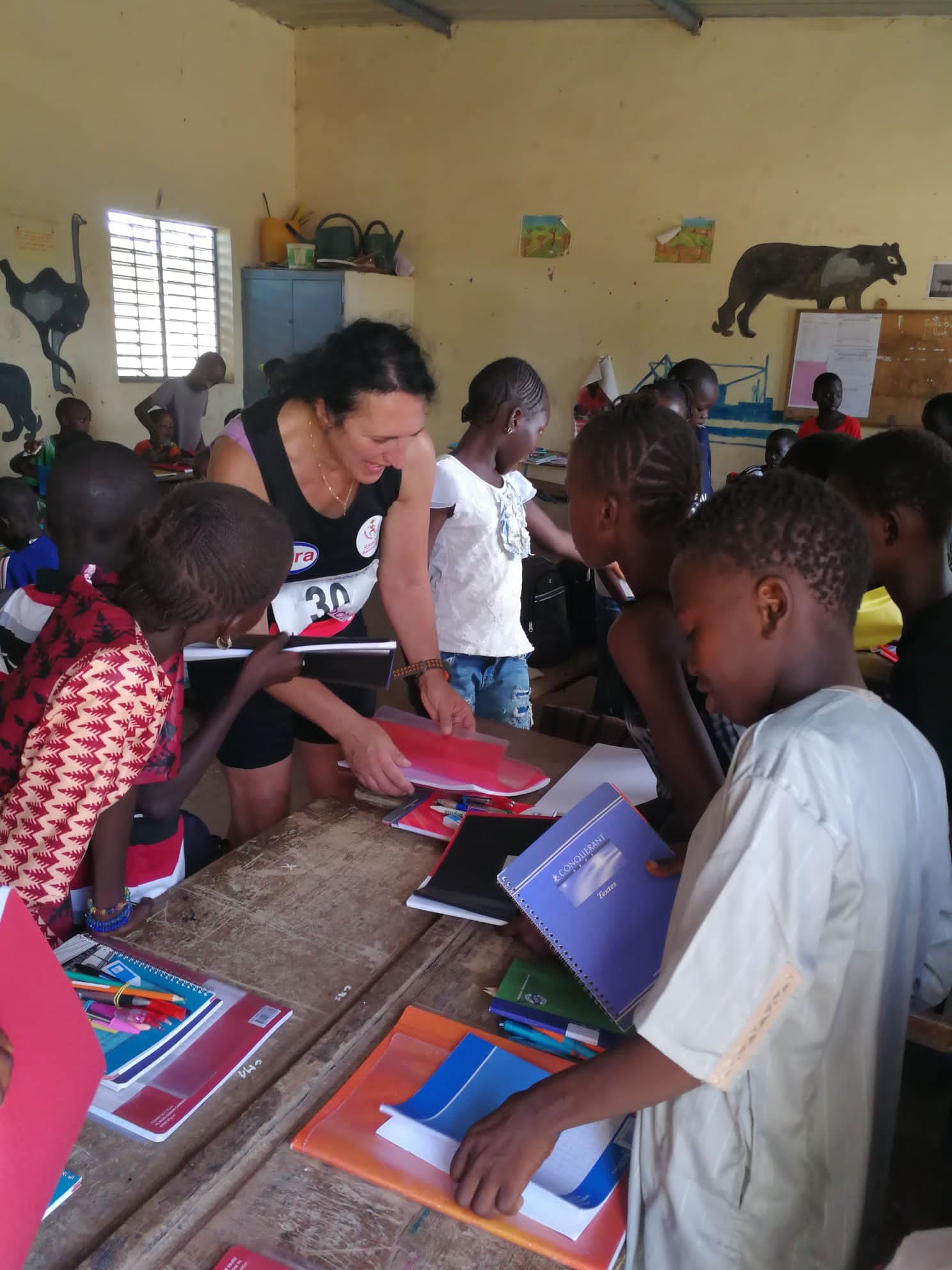Remise de fournitures scolaires à des enfants dans une classe